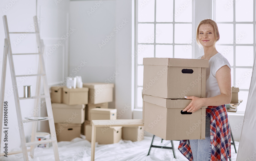 A beautiful single young woman unpacking boxes and moving into a new home A beautiful single young woman unpacking boxes and moving into a new home