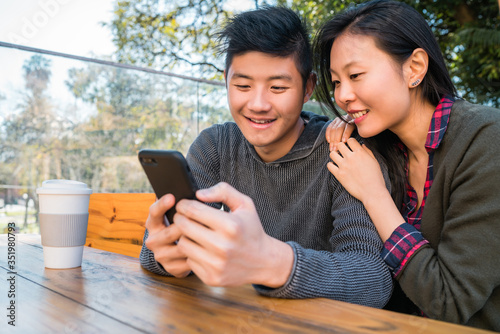 Asian couple looking at the mobile phone.