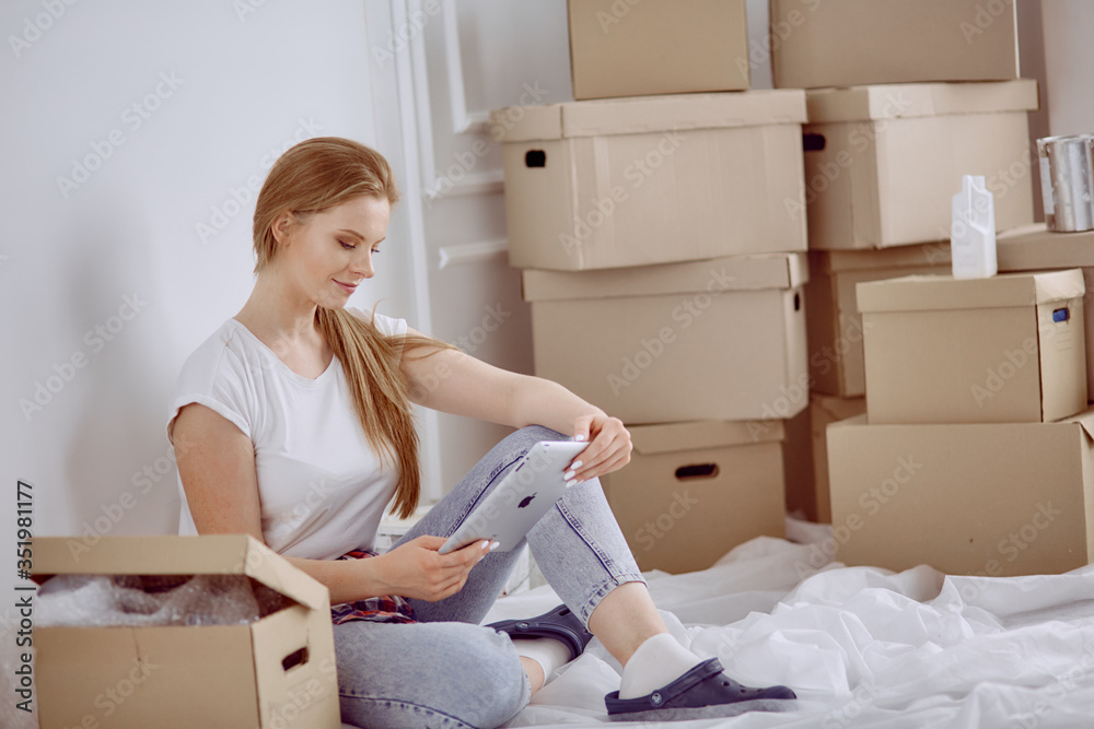 A beautiful single young woman unpacking boxes and moving into a new home A beautiful single young woman unpacking boxes and moving into a new home