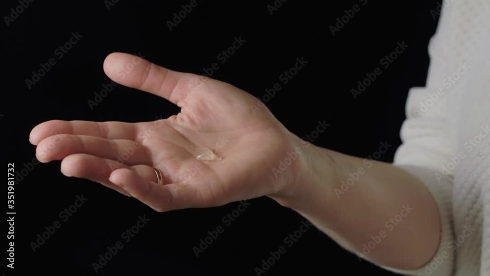 Young woman washing hands with alcohol sanitizer gel, daily hygiene routine protection for coronavirus covid 19 infection spreading prevention, coronavirus health care concept over black background Young woman washing hands with alcohol sanitizer gel, daily hygiene routine protection for coronavirus covid 19 infection spreading prevention, coronavirus health care concept over black background