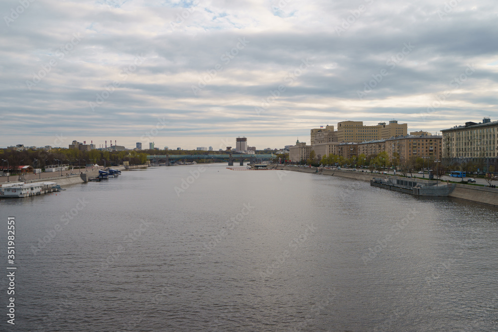 Moscow cityscape in in day. Wide Moskva River. Closed public Groky Park on left, Frunzenskaya embankment on right. Academy of Sciences, Andreevsky /Pushkinsky pedestrian bridge, Ministry of Defence