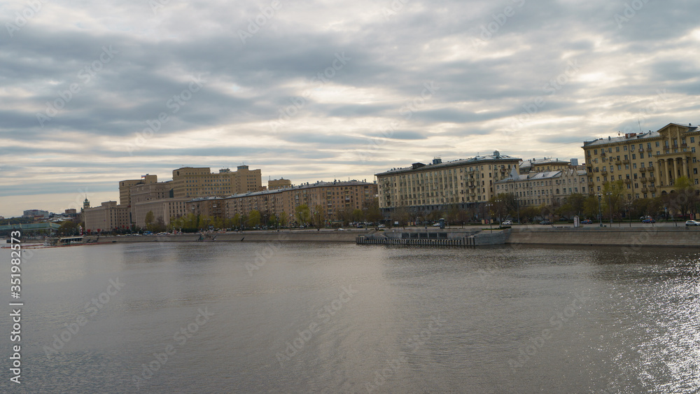 Moscow cityscapein overcast spring day. Wide Moskva River. Architecture. Frunzenskaya embankment. Andreevsky (Pushkinsky) pedestrian bridge and the building of the Ministry of Defence. in distance