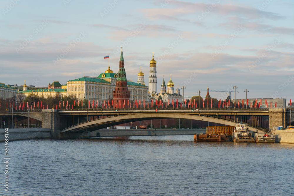 Moscow cityscape in spring. Kremlin wall, Towers, Residence of President of the Russian Federation, Ivan the Great Bell Tower, Dormition Cathedral, Bolshoy Kamenny Bridge is decorated by red flags