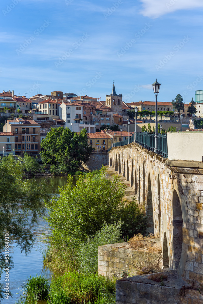 Stone bridge over Douro river and Zamora city in background. Castilla y Leon, Spain.