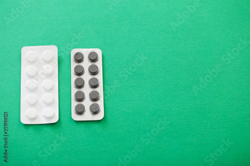 pills in blisters on green background