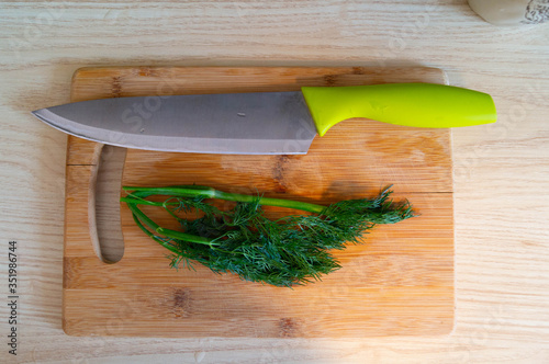 kitchen knife on wooden Board with dill