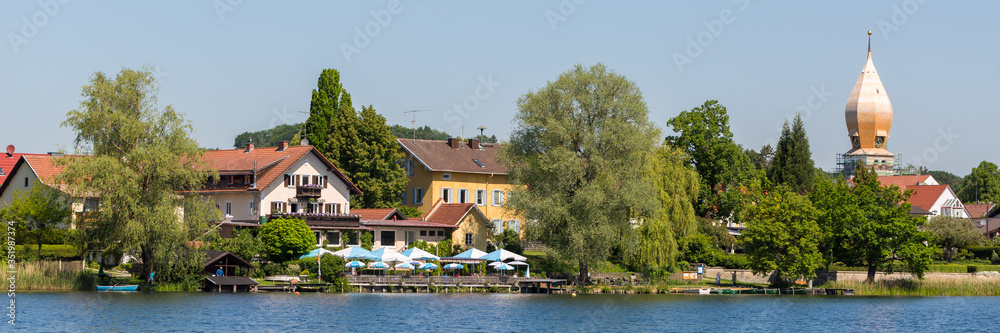 Panorama of Weßling with beer garden, church and lake.