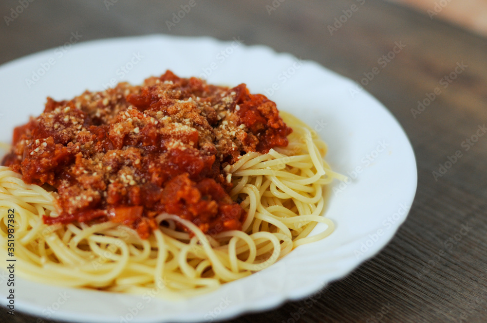 Fresh tasty spaghetti bolognaise served on plate on wooden table.