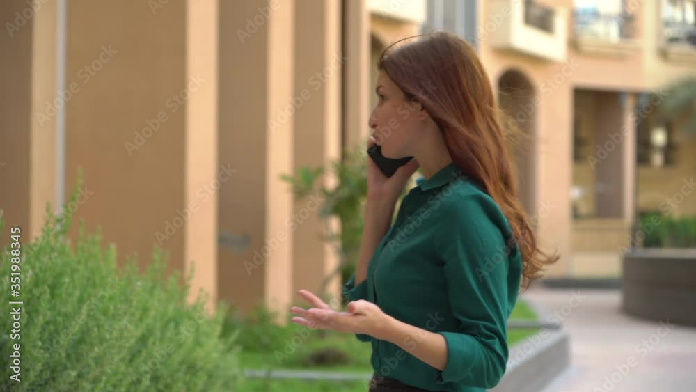girl nervously talking on the phone outside. negative conversation. middle plane girl nervously talking on the phone outside. negative conversation. middle plane