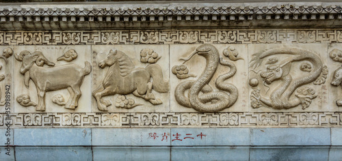 Chinese zodiac signs carved in stone on the wall.