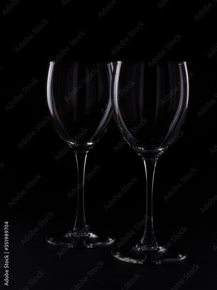 Wine glasses on black backround and wine bottles