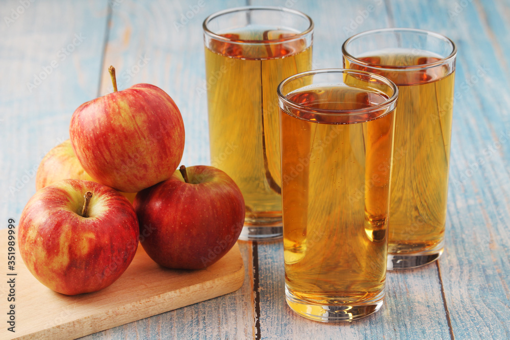 Glasses with apple juice and ripe apple Glasses with apple juice and ripe apple