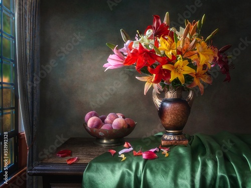 Still life with bouquet of multicolored lily and peaches photo