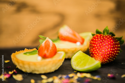 Sweet dessert Tartlets with fresh strawberries and delicious cream. Closeup