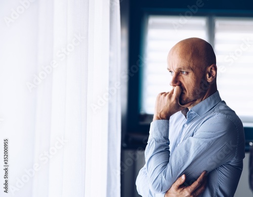 Obraz na płótnie Worried businessman in office. Thoughtful man looking through the window. w salonie