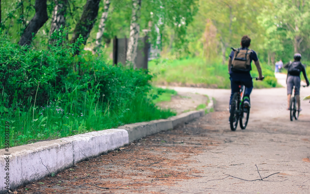 Fototapeta premium A man riding a bike down a dirt roadundefined