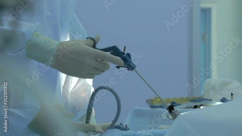 Close-up of surgeon's hands in operating room, real laparoscopic operation is performed, removal of tumor from abdominal cavity, adroit movements of doctor, professional, work with assistant