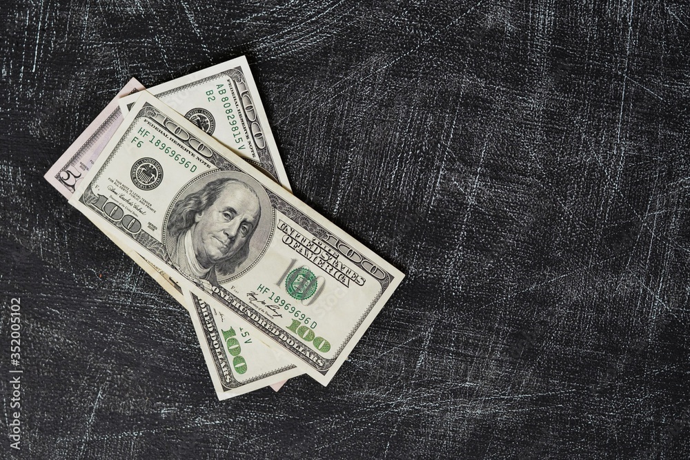 few dollar banknotes on black scratched surface few dollar banknotes on black scratched surface