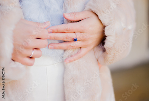 Close up of a woman's hand with blue sapphire engagement ring photo