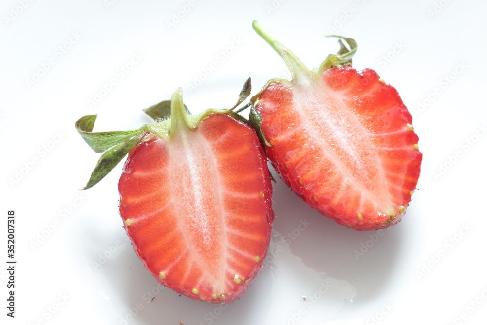 Fresh red strawberry cut in half on a white background. Healthy food