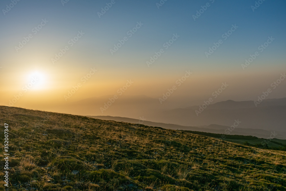 Sunrise over a meadow with the peaks of Sierra Nevada in the background