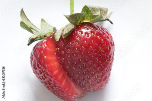 Fresh red strawberry cut in half on a white background. Healthy food