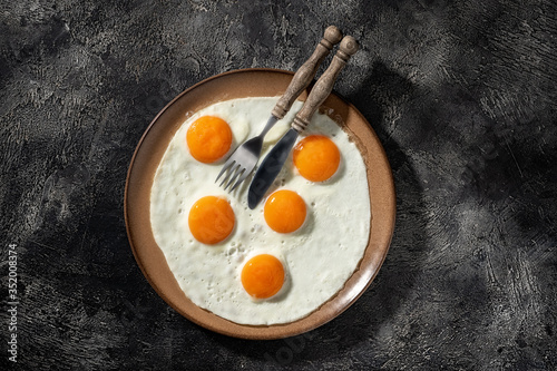Fried eggs on a ceramic plate with fork