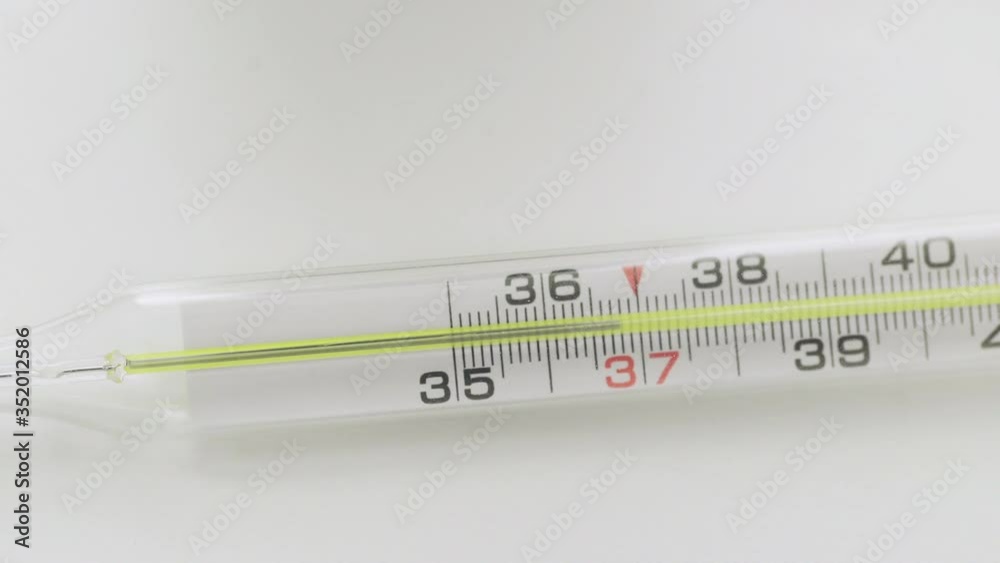 Glass mercurial thermometer takes temperature on white background Corona. Covid-19 Glass mercurial thermometer takes temperature on white background Corona. Covid-19