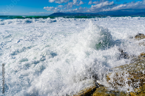 Beautiful white sea foam on the beach during a storm. Waves roll on the shore. Black Sea photo