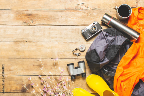 Bilde på lerret Boots for trail, binoculars, trekking accessories on a wooden background