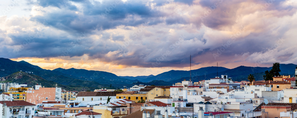 Panoramic view urban district, with sunset and mountains in background