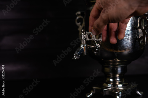 Samovar stands on a wooden surface