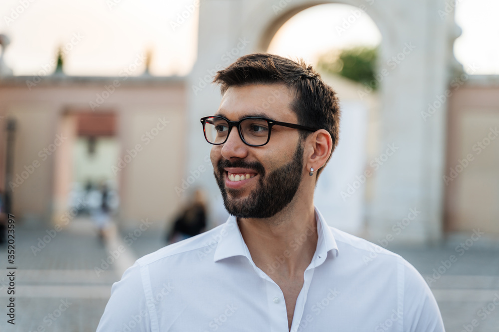 Young business man with glasses, white shirt and tie in outdoor city smiling