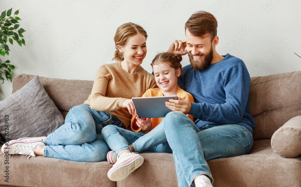 Smiling family using tablet together on sofa.