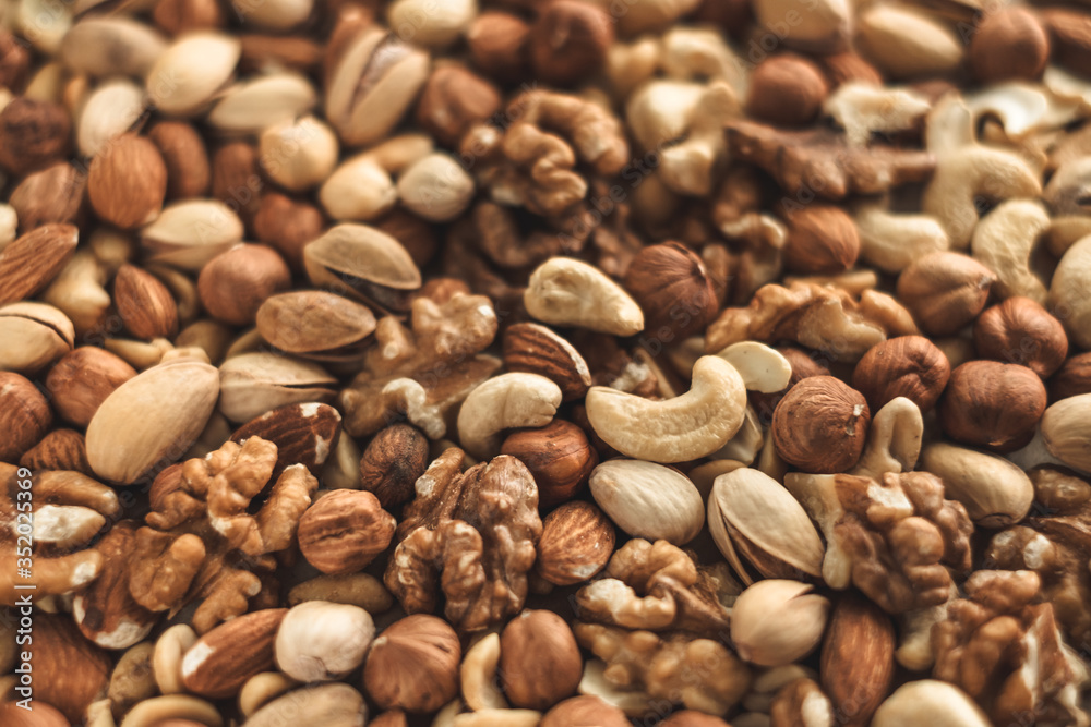 Naklejka premium Different types of nuts, nut mix of almonds, hazelnuts, cashews, peanuts texture background. Close up
