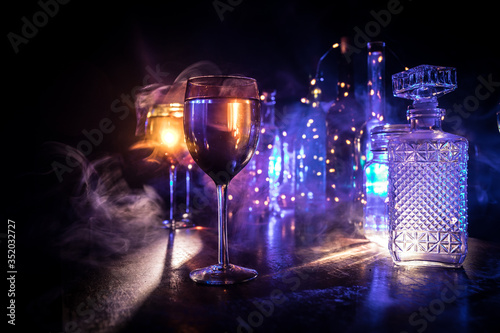 Goblet of white wine on wooden table on wooden wall background