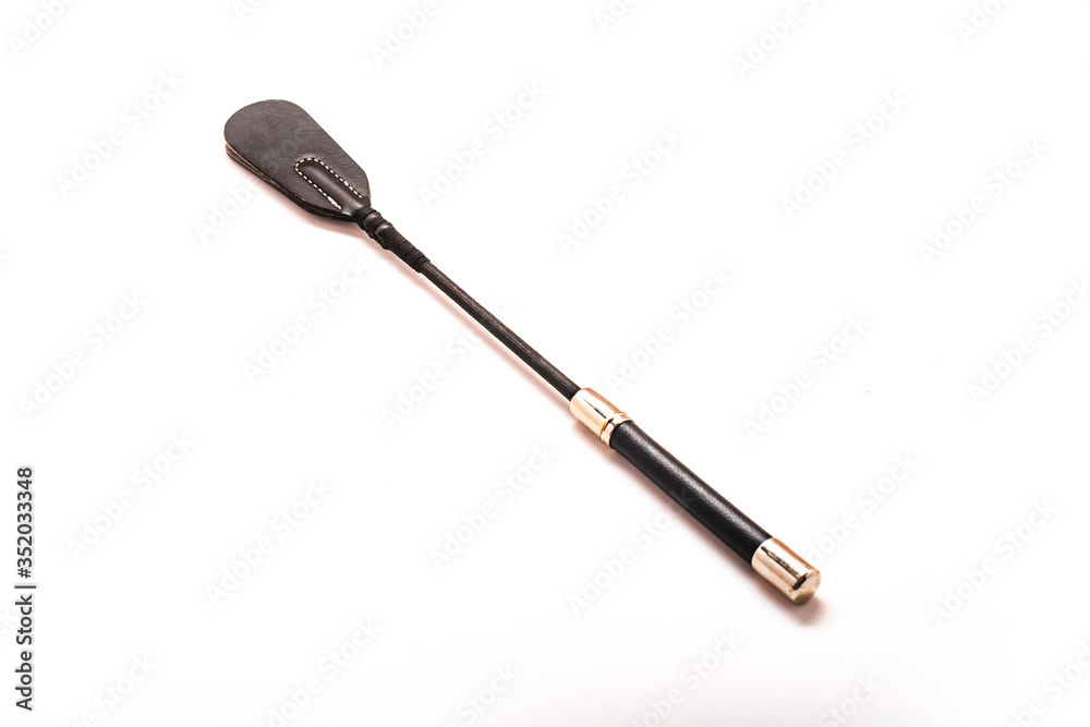 Queen Riding Crop Horse Whip on white background. Accessories for adult sexual games. Toys for BDSM, spanking devices. Spanking and punishment concept. Isolated on white background, copy space. Queen Riding Crop Horse Whip on white background. Accessories for adult sexual games. Toys for BDSM, spanking devices. Spanking and punishment concept. Isolated on white background, copy space.