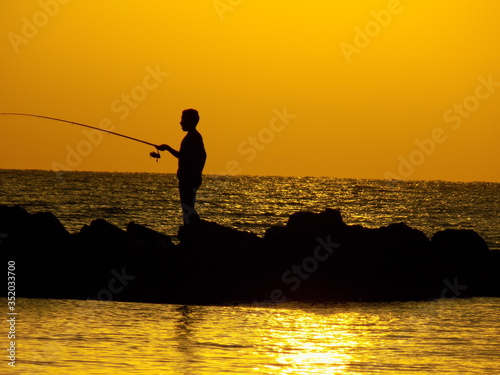 Fishing at sunset, the salt on the big ocean