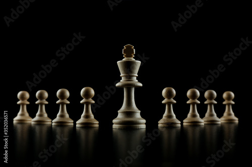 white king with an army of pawns on a black background