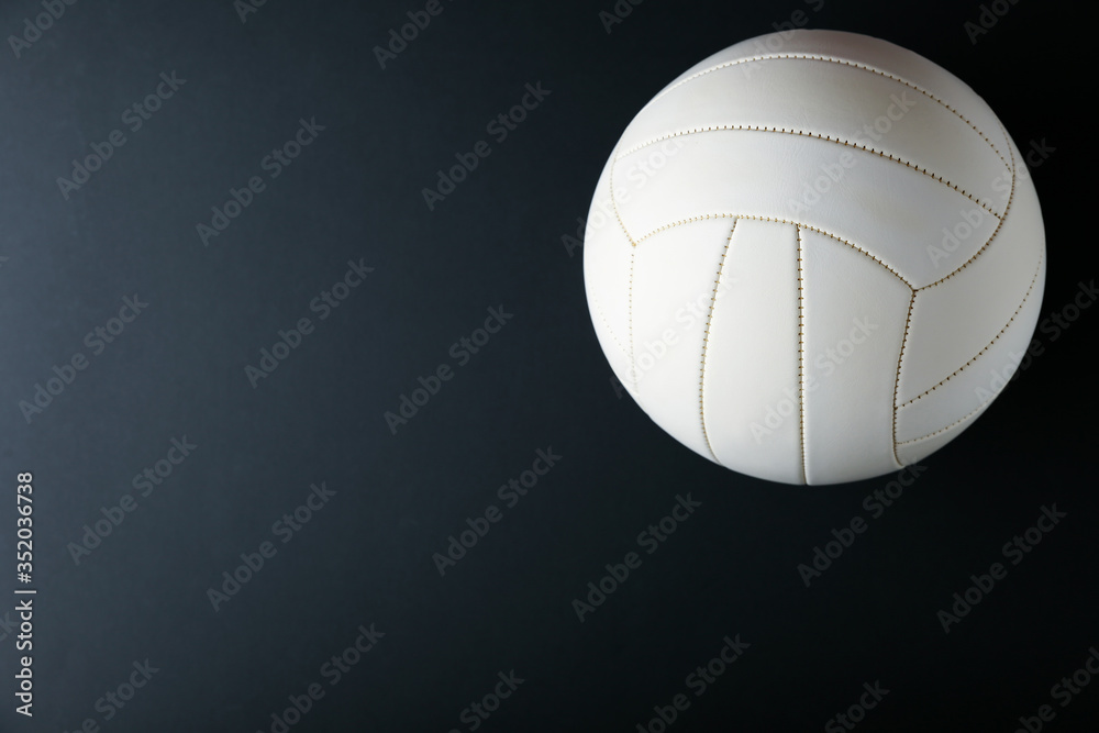 volleyball ball on black background. 
 white volleyball ball with copy space