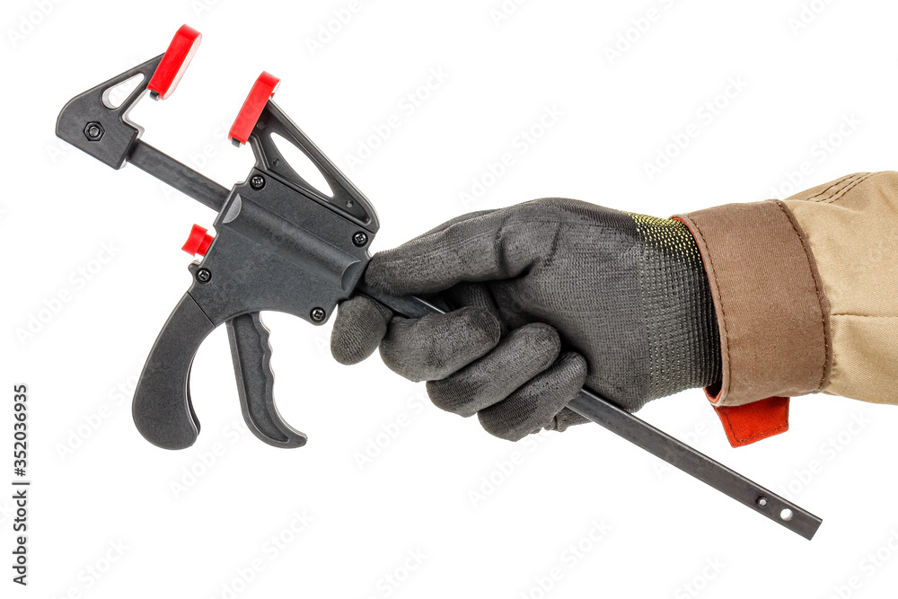 Quick release clamp in worker hand in black protective glove and brown uniform isolated on white background Quick release clamp in worker hand in black protective glove and brown uniform isolated on white background
