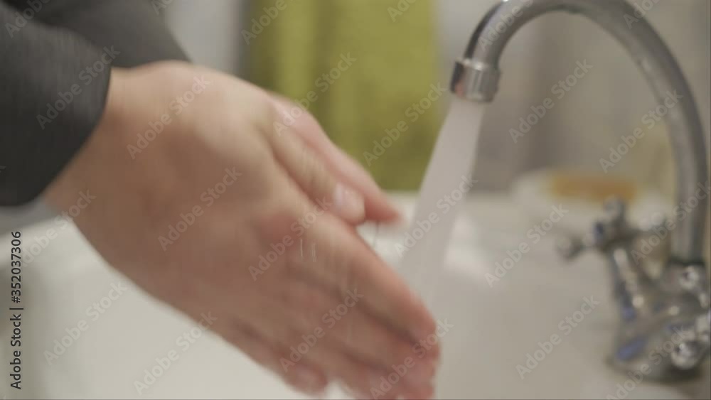 A man in a dark hoodie takes soap and thoroughly washes his hands. quarantine pandemic COVID 19 hand washing. Stay home concept. Prores 422. A man in a dark hoodie takes soap and thoroughly washes his hands. quarantine pandemic COVID 19 hand washing. Stay home concept. Prores 422.