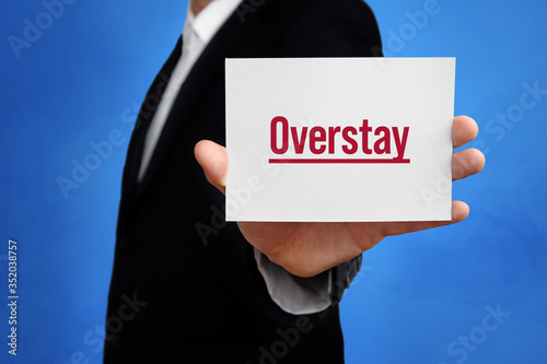 Overstay. Lawyer holding a card in his hand. Text on the board presents term. Blue background. Law, justice, judgement photo