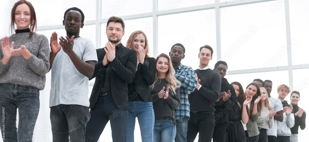 diverse young people applaud standing in line