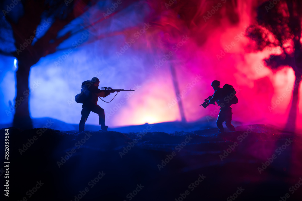 Army sniper with large caliber rifle standing in the fire and smoke. War Concept. Battle scene on war fog sky background, Fighting silhouettes Below Cloudy Skyline at night. City destroyed by war