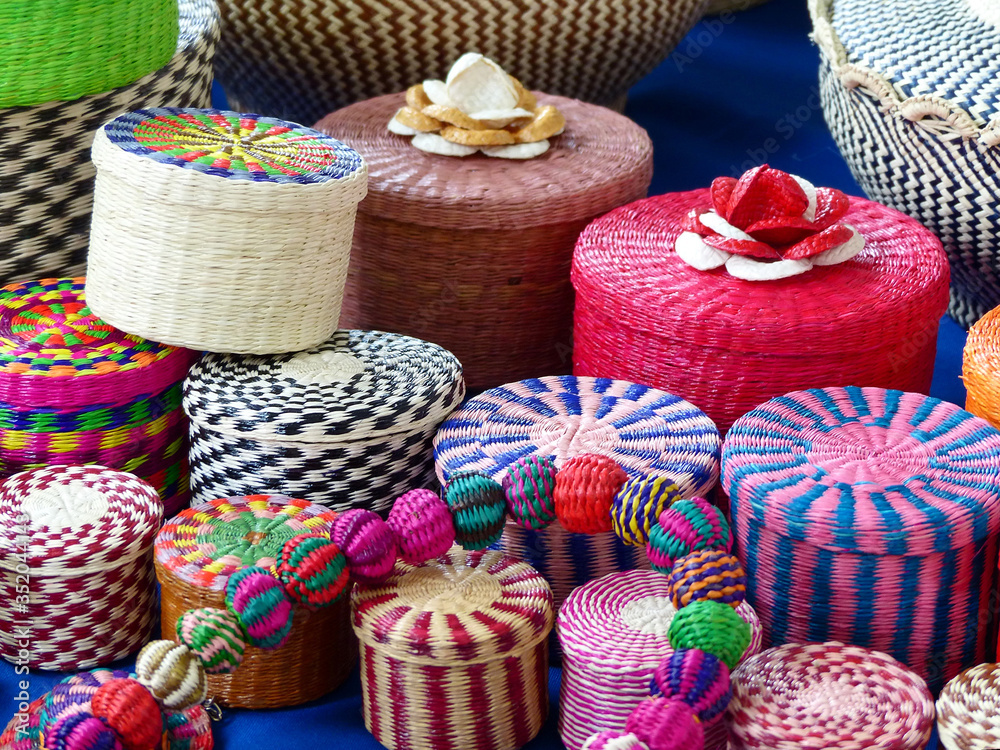 Various wicker souvenirs - baskets, vases, placemats - made from toquilla straw, vegetable fiber, and painted with various colors at the artisan market in Cuenca, Ecuador
