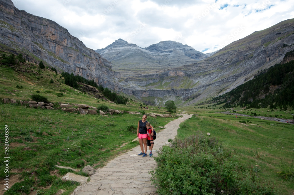 mujer joven hace senderismo con un niño. Foto a pies de una gran montaña . El sendero va hasta ella mujer joven hace senderismo con un niño. Foto a pies de una gran montaña . El sendero va hasta ella