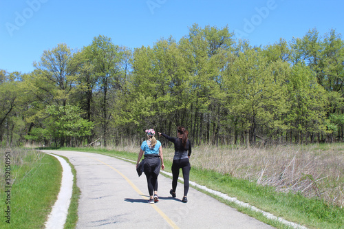 Woman pointing at something to another woman on the North Branch Trail at Miami Woods in Morton Grove  Illinois