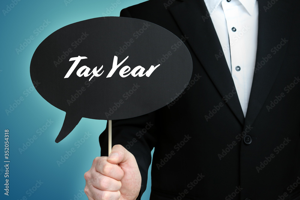 Tax Year. Lawyer (Man) holds the sign of a speech bubble in his hand. Text on the label. Symbol of law, justice, judgement Tax Year. Lawyer (Man) holds the sign of a speech bubble in his hand. Text on the label. Symbol of law, justice, judgement