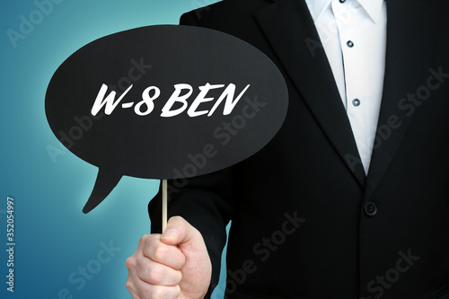 W-8 BEN. Lawyer (Man) holds the sign of a speech bubble in his hand. Text on the label. Symbol of law, justice, judgement photo